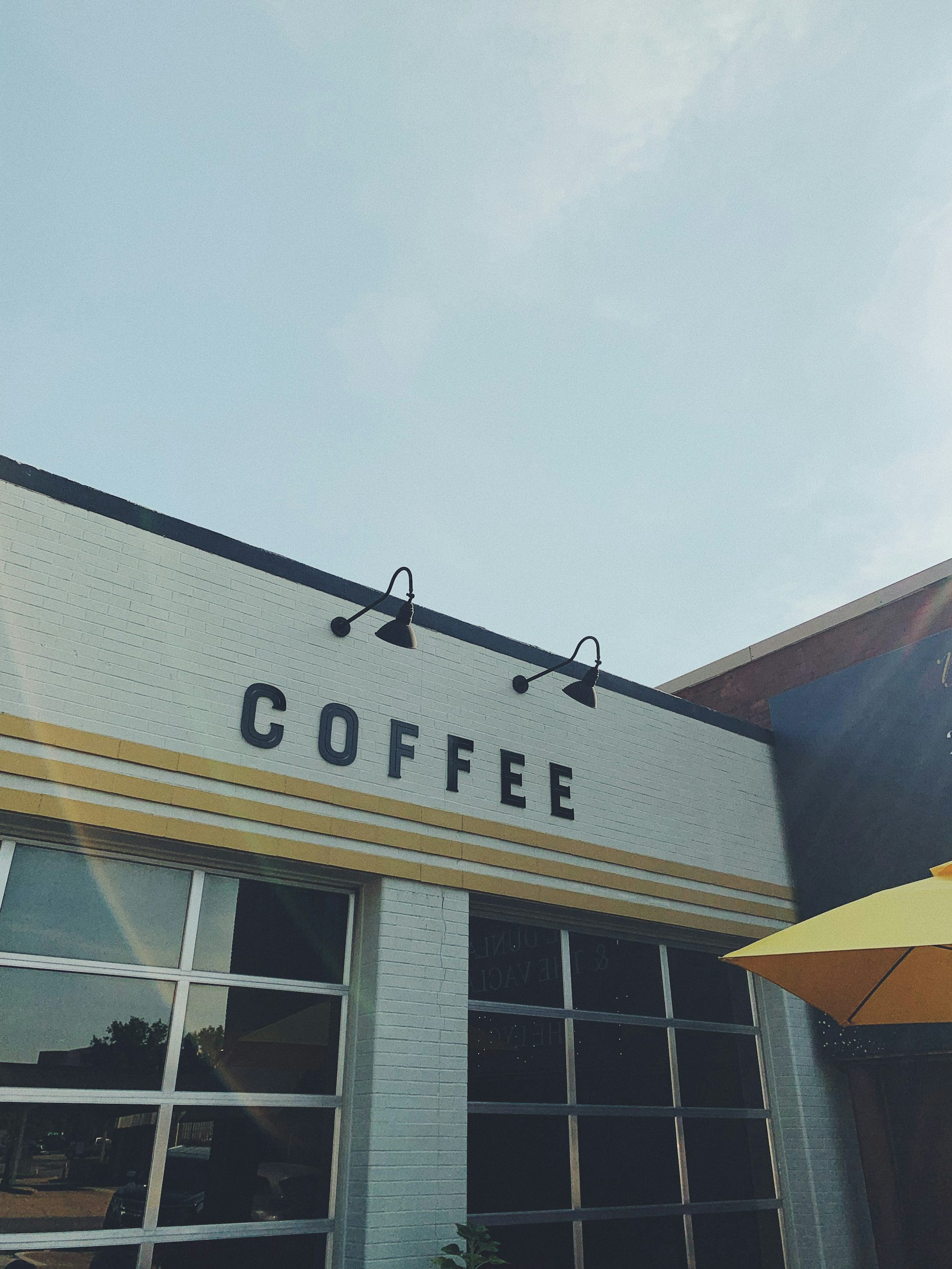 yellow umbrella in front of blue and white building